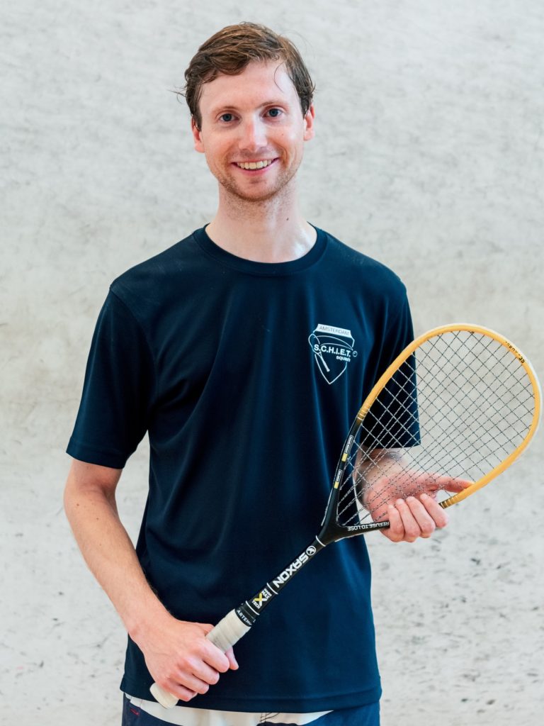 Squash coach Mark Bennis holding a racket