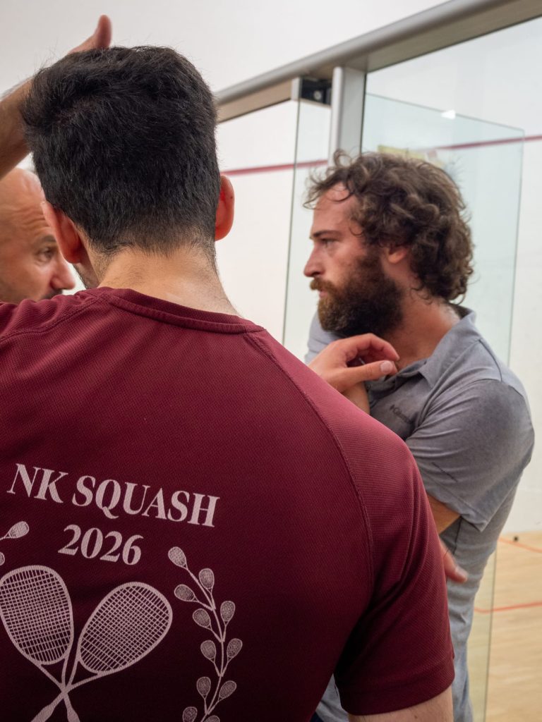Players discussing a match beside the squash court.