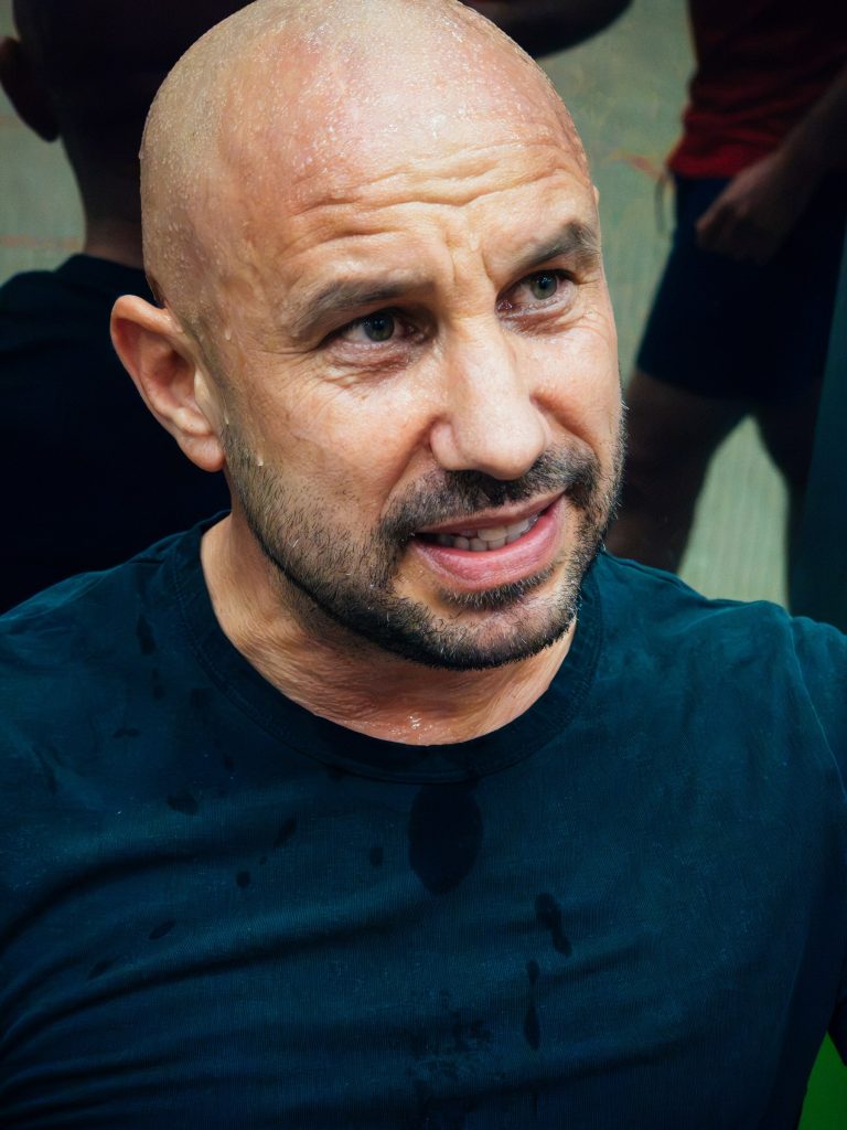 A player in a dark shirt resting beside the squash court.