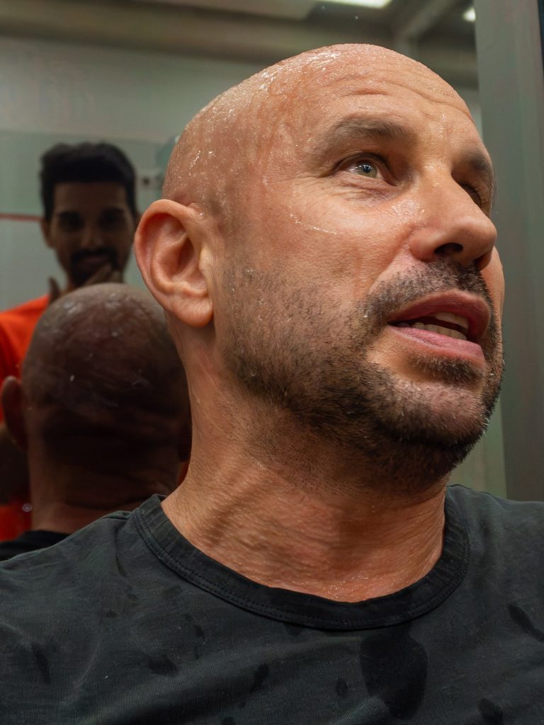 A player looking up while resting beside the squash court.