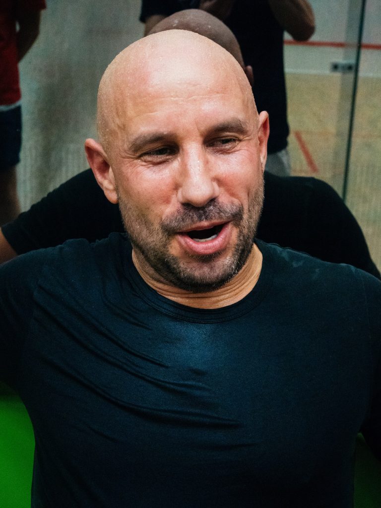 A player in a dark shirt talking between matches.