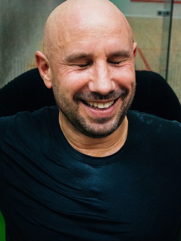 A smiling player in a dark shirt between matches.