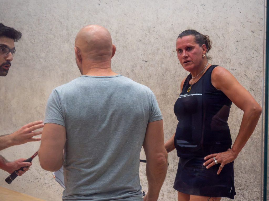 Players talking together at the glass court door.