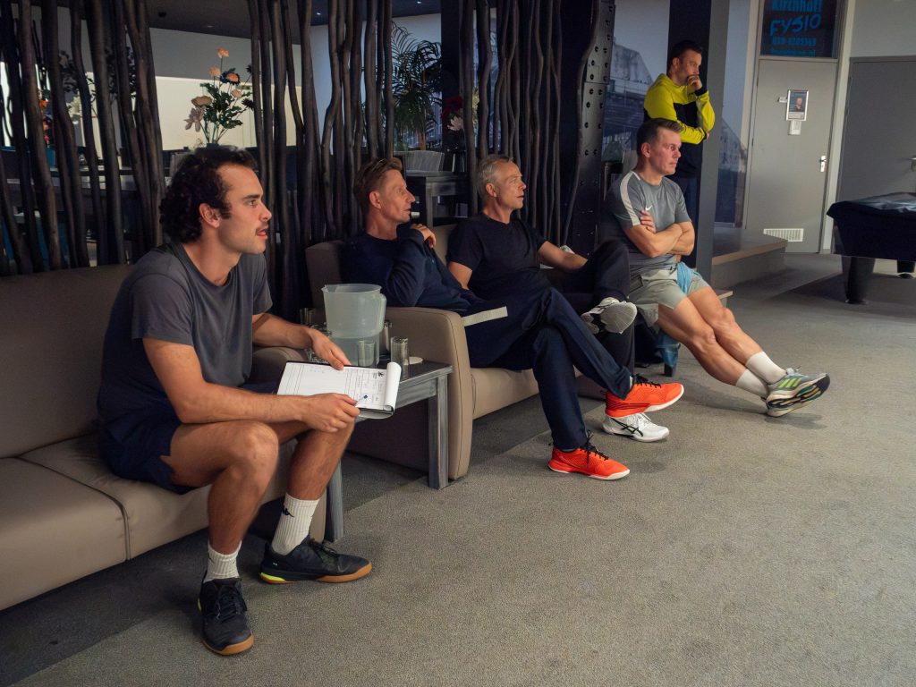 Players watching the squash matches from seats beside the courts at Squash City.